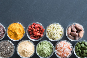 Selection of superfoods on a black background with copy space
