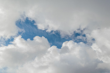 Fluffy,swirling clouds in the blue sky.