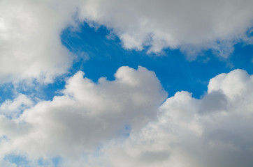 Fluffy,swirling clouds in the blue sky.