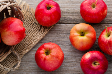 Ripe red apples on wooden background.