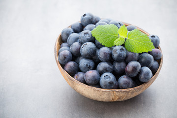 Fresh blueberries natural coconut in a bowl on a gray background.