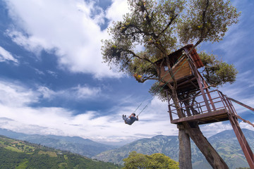 Unknown person swinging at the La casa del Arbol in Banos de Agua Santa, Ecuador