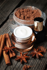 Chocolate skin treatment. Cosmetic jar with lotion, cocoa, anise, cinnamon sticks.