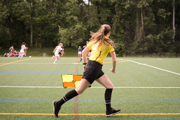 Lineswoman running along the sideline 