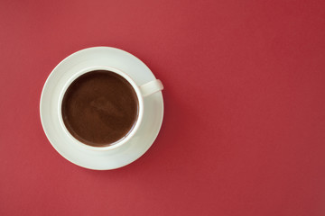 Coffee in white cup on red background.