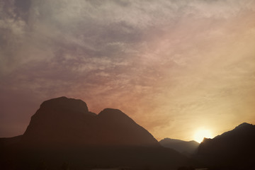Silhouettes of the mountain hills at sunset. Mountain cascade