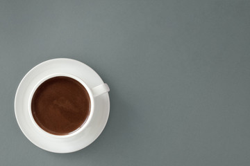 Coffee in white cup on gray background.