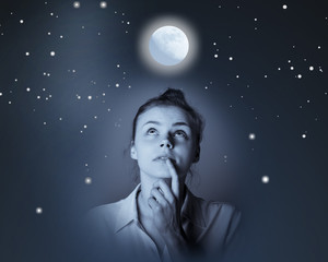 Naklejka premium Young slim woman looking at full moon