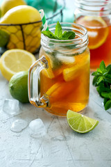 Iced tea, summer cold drink  with lemon and mint, limes and ice cubes, refreshment