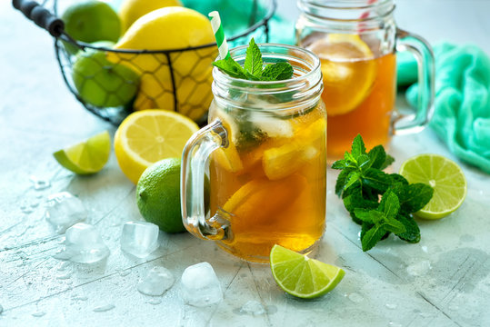Iced tea, summer cold drink  with lemon and mint, limes and ice cubes, refreshment