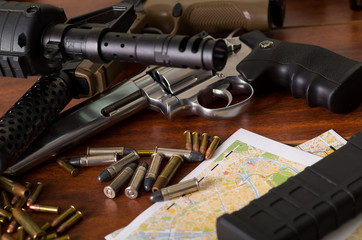 Obraz premium Bullets and a firearm. Bullets are a projectile expelled from the barrel of a firearm over a map, on wooden table
