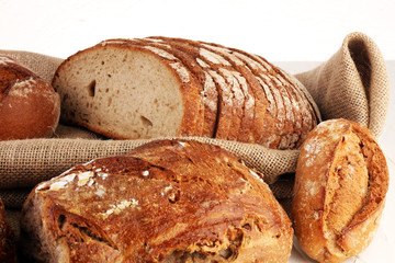 Different kinds of bread and bread rolls on board from above. Kitchen or bakery poster design.