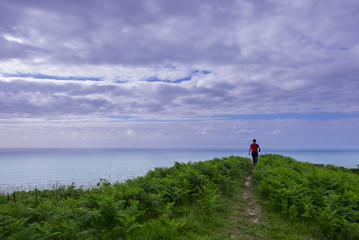 Man doing sport, walking on the mountain near the sea, Basque country