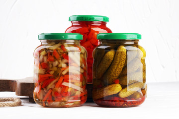 Jar with variety of pickled vegetables. Carrots, field garlic, cucumber in glas. Preserved food