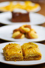 Close up of a delicious traditional turkish food baklava with pistachio on a white plate in blurred background