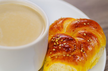 Close up of a delicious mediterranean breakfast, fresh bread on a table with a cup of milk chocolate on wooden background