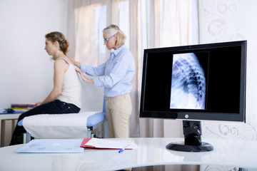 Fototapeta premium Doctor examining patient's back