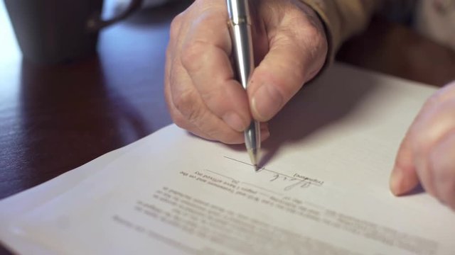 Senior man signing a legal document