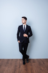 Full size portrait of stylish young brunete banker standing on gray background. He looks stunning!...