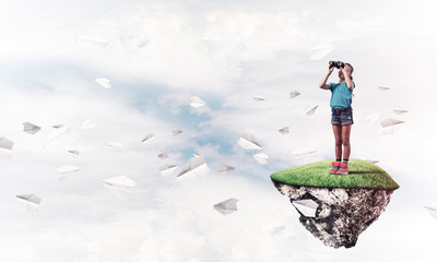 Concept of careless happy childhood with girl looking in binocul
