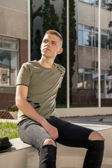 Handsome man outdoors portrait. Teenager looking in the camera