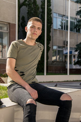 Handsome man outdoors portrait. Teenager looking in the camera