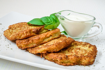 Delicious fried patties with herbs and sauce, on a white plate. Horizontal frame