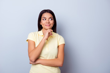 Obraz premium Portrait of playful dreamy young latino american brunete lady, she stands in yellow tshirt on pure light background. So pensive and sexy, flirty and attractive