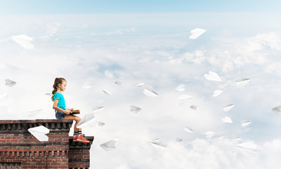 Concept of careless happy childhood with girl and paper plane flying around