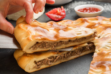 Human hand takes a piece of delicious cake