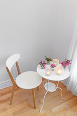 Elegant white interior with candle lights and spring flowers