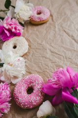 Beautiful flowers and mouth-watering donuts lie on kraft paper