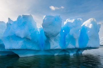 Fototapeta na wymiar Blue shimmering beautiful iceberg in Antarctica