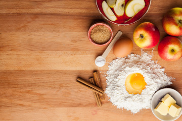 apple pie ingredients on wooden table.