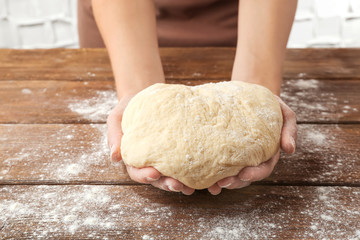 Woman holding dough for pizza