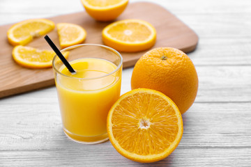 Oranges with juice on wooden table