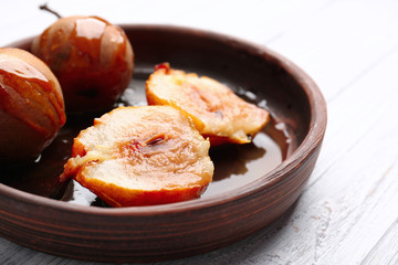 Baked pears with syrup served in wooden plate