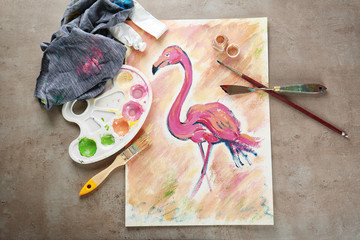 Naklejka premium Beautiful flamingo painting with artist supplies on table