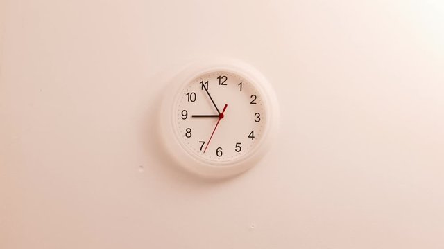 Nobody. White clock on wall ticking showing nine hours, time lapse 4K