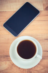 Fototapeta na wymiar Smartphone, mobile phone with blank screen and cup of coffee