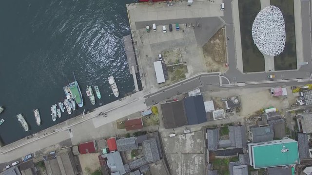 漁船とフェリーが停泊する港町を真上から撮影
