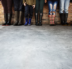 Group of people standing in a row with copy space on concrete floor