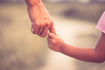 Father and daughter holding hand together in vintage color tone