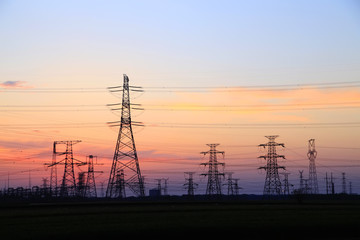 Fototapeta na wymiar The silhouette of high voltage towers