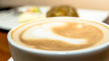 a cup of coffee with food as the background