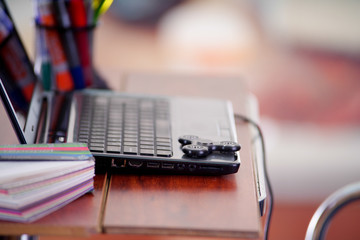 A popular fidget spinner toy over the laptop, on office background
