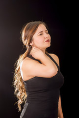 Naklejka premium Beautiful young lady Suffer crick after workout in a black background