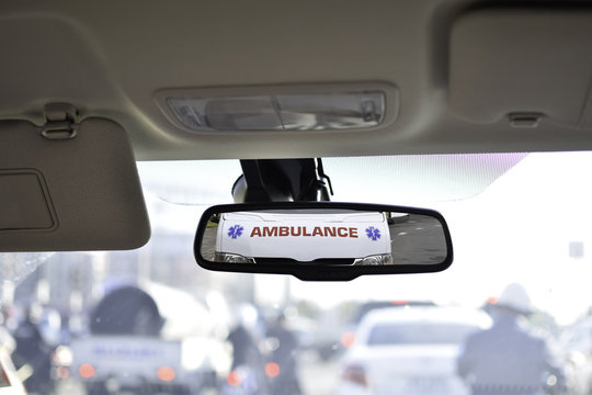 Ambulance in the rear mirror of car