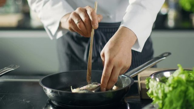 Famous Restaurant Chef Turns Over Fish on a Hot Pan. Close-up Shot of Pan with Picturesque Vegetables Seen. Shot on RED EPIC-W 8K Helium Cinema Camera.