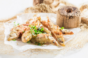 Roasted smelt fish with salt and herbs on white background